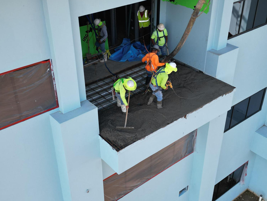 Photo of workers setting down concrete..